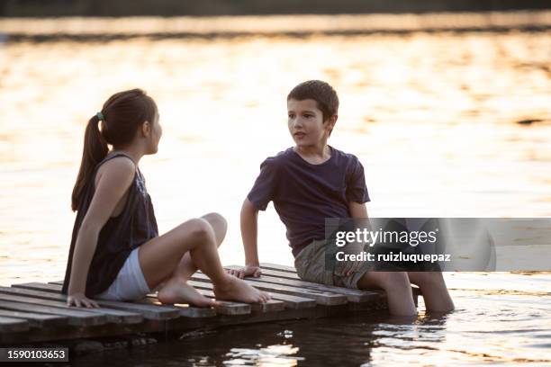 two children playing on a lake dock - 9 loch stock pictures, royalty-free photos & images