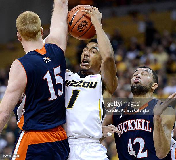 Missouri's Phil Pressey, center, is stopped by Bucknell's Joe Willman and Cameron Ayers, as he drove to the basket in the first half at Mizzou Arena...