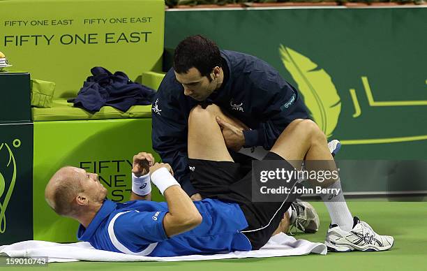 Nikolay Davydenko of Russia gets a medical evaluation during the final against Richard Gasquet of France on day six of the Qatar Open 2013 at the...