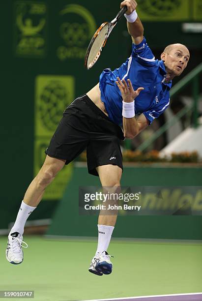 Nikolay Davydenko of Russia serves during the final against Richard Gasquet of France on day six of the Qatar Open 2013 at the Khalifa International...