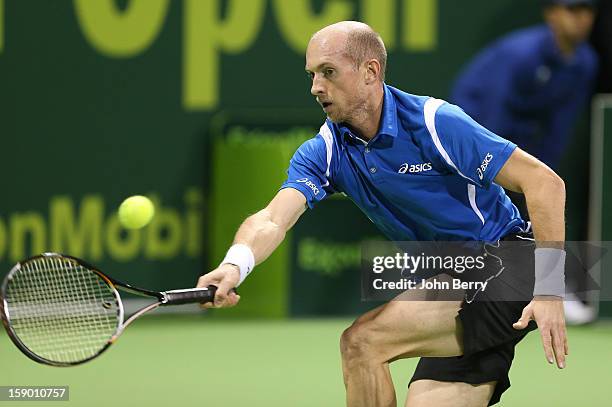 Nikolay Davydenko of Russia plays a forehand during the final against Richard Gasquet of France on day six of the Qatar Open 2013 at the Khalifa...