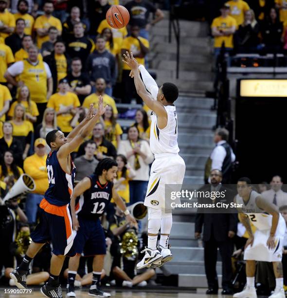Missouri's Phil Pressey has the attention of head coach Frank Haith and teammate Jabari Brown, right, as he puts up a three-pointer over Bucknell's...