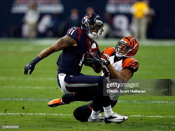DeVier Posey of the Houston Texans makes a reception against Leon Hall of the Cincinnati Bengals during their AFC Wild Card Playoff Game at Reliant...