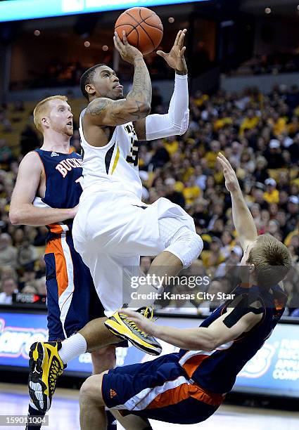 Missouri's Earnest Ross flattens Bucknell's Steven Kasper on his way to the hole during the first half at Mizzou Arena in Columbia, Missouri,...