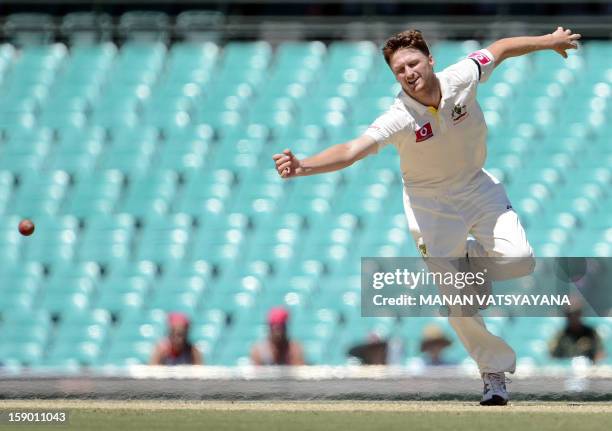 Australian fastbowler Jackson Bird tries to stop a shot off his bowling on the fourth day of the third cricket Test match between Australia and Sri...