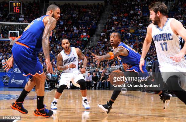 Orlando Magic guard Jameer Nelson passes inside to forward Josh McRoberts , between New York Knicks defenders Tyson Chandler and J.R. Smith , during...