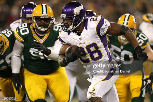 Running back Adrian Peterson of the Minnesota Vikings runs the ball in front of nose tackle B.J. Raji of the Green Bay Packers in the second half...