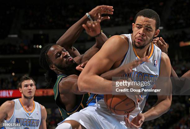 JaVale McGee of the Denver Nuggets grabs a rebound away from DeMarre Carroll of the Utah Jazz at the Pepsi Center on January 5, 2013 in Denver,...