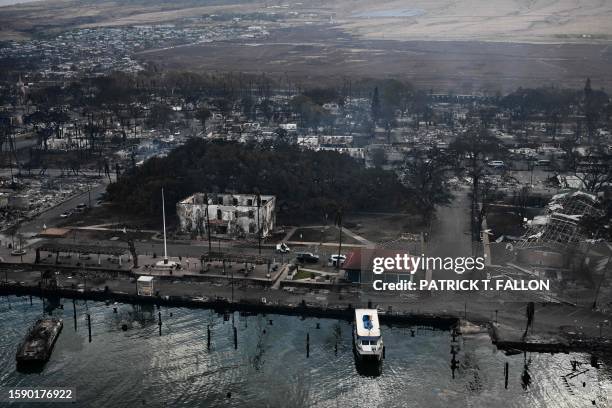 An aerial view shows the historic Banyan Tree along with destroyed homes, boats, and buildings burned to the ground in the historic Lahaina town in...