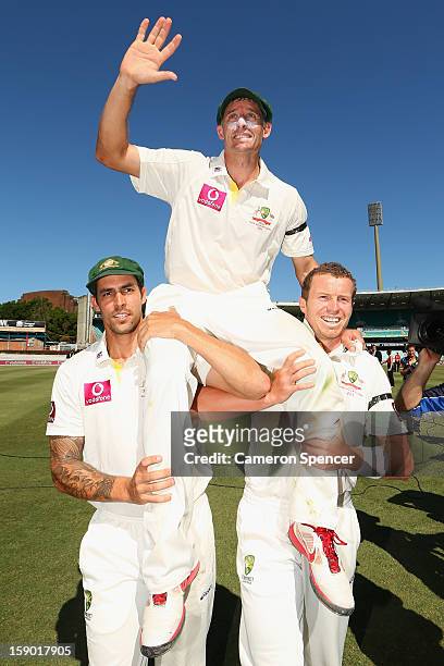 Michael Hussey of Australia is chaired off the field by team mates Mitchell Johnson and Peter Siddle after playing his last test, winning day four of...