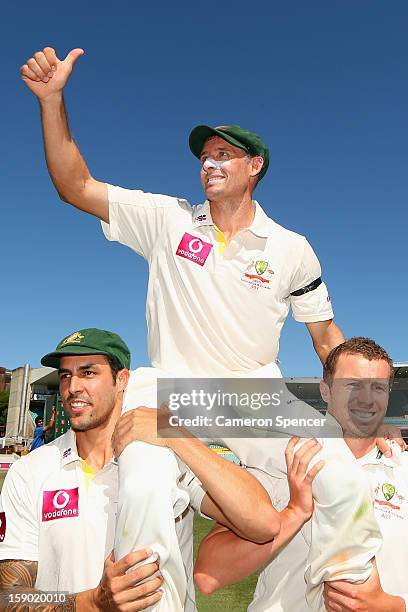 Michael Hussey of Australia is chaired off the field by team mates Mitchell Johnson and Peter Siddle after playing his last test, winning day four of...