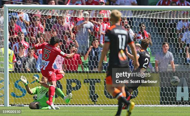 David Williams of the Heart colldides with goalkeeper Michael Theo of the Roar as he scores the Hearts first goal during the round 15 A-League match...