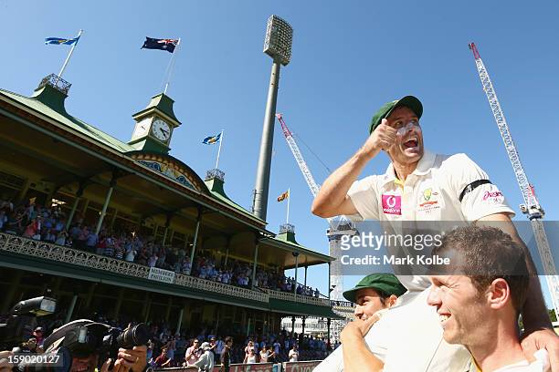 Michael Hussey of Australia gives the thumbs up as he is chaired from the filed by Mitchell Johnson and Peter Siddle after his retirement from...