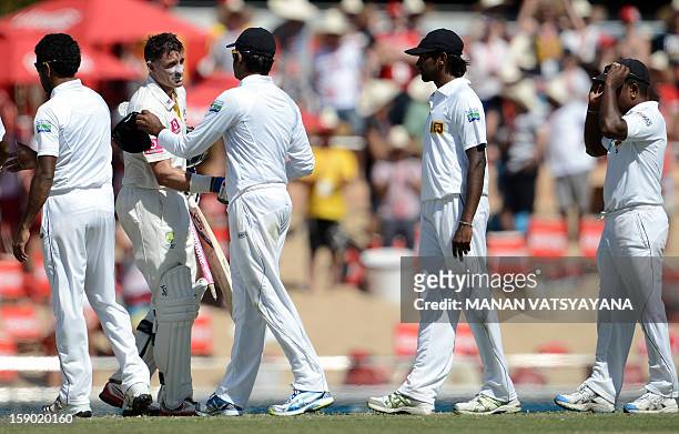 Australian cricketer Michael Hussey is congratulated by Sri Lankan cricketers as walks off the field after defeating Sri Lanka on the fourth day of...