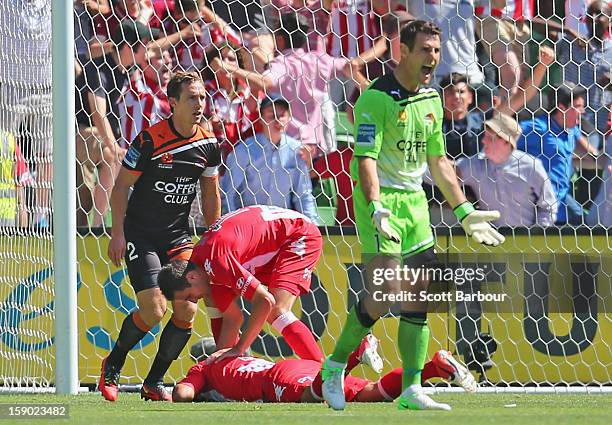 David Williams of the Heart falls to the ground after colliding with goalkeeper Michael Theo of the Roar as he scores the Hearts first goal during...