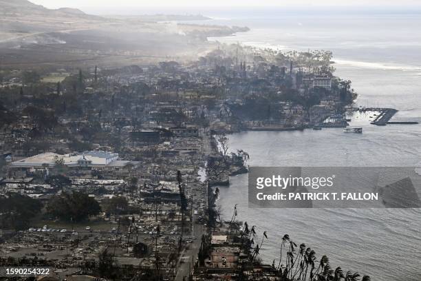 An aerial image taken on August 10, 2023 shows destroyed homes, buildings, and the harbor area burned to the ground in Lahaina in the aftermath of...