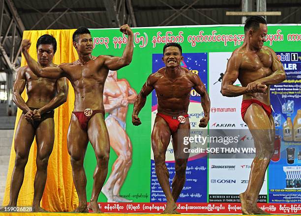 Myanmar men strike poses during a body building contest held as part of celebrations to mark Myanmar's 65th Independence Day at a stadium in Yangon...