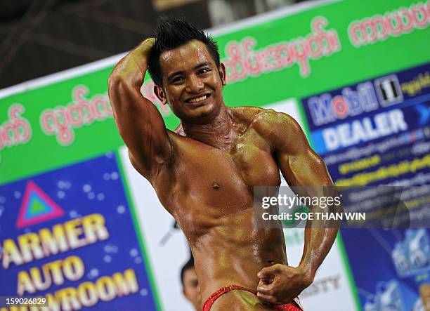 Myanmar man strikes a pose during a body building contest held as part of celebrations to mark Myanmar's 65th Independence Day at a stadium in Yangon...