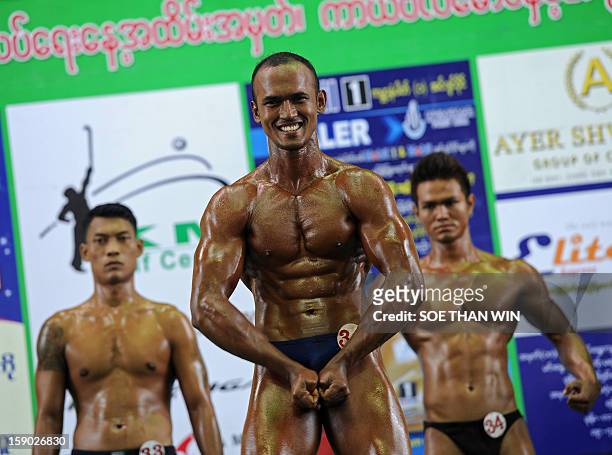 Myanmar man strikes a pose during a body building contest held as part of celebrations to mark Myanmar's 65th Independence Day at a stadium in Yangon...