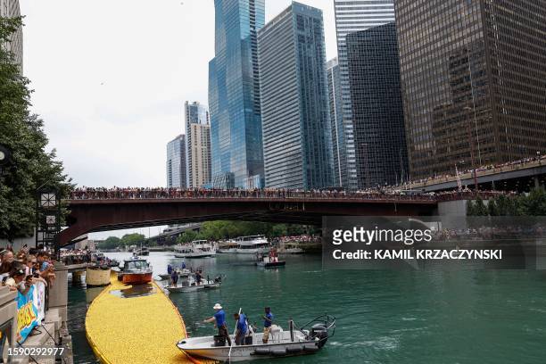 Onlookers watch as 75,000 rubber ducks are raced down the Chicago River during the Chicago Duck Derby in Chicago, Illinois, on August 10, 2023. The...