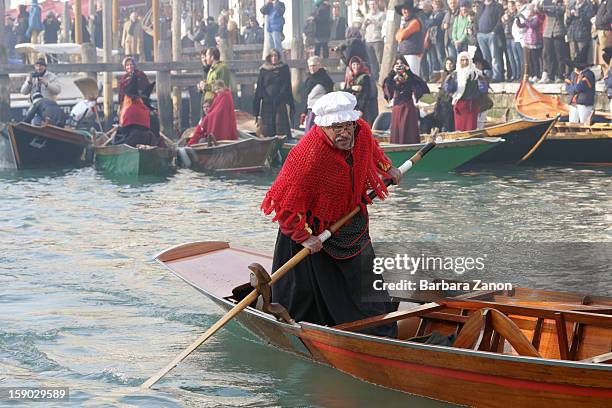 Participant dressed as 'Befana' rows on Gran Canal during the traditional Epiphany Boat Race on January 6, 2013 in Venice, Italy. In Italy, Epiphany...