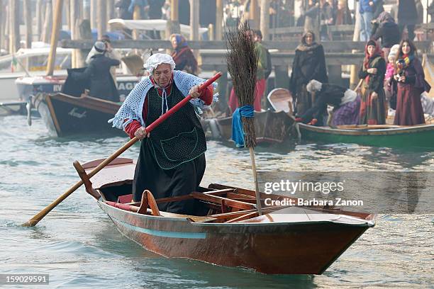 Participant dressed as 'Befana' rows on Gran Canal during the traditional Epiphany Boat Race on January 6, 2013 in Venice, Italy. In Italy, Epiphany...