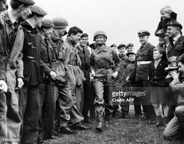 Photo taken on April 12, 1959 in London shows French actress Brigitte Bardot, flanked by Royal Air Force boys, arriving at the R.A.F. Base on the set...