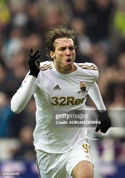 Swansea City's Spanish striker Miguel Michu celebrates scoring the opening goal against Arsenal during the FA Cup third round football match at the...