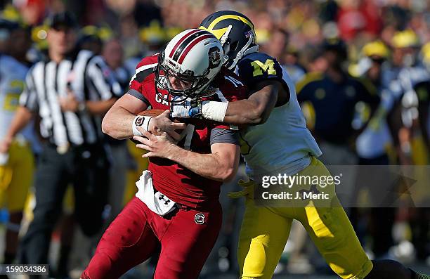 Defensive back Raymon Taylor of the Michigan Wolverines runs down quarterback Connor Shaw of the South Carolina Gamecocks during the Outback Bowl...