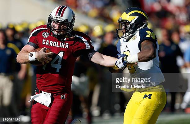 Defensive back Raymon Taylor of the Michigan Wolverines runs down quarterback Connor Shaw of the South Carolina Gamecocks during the Outback Bowl...