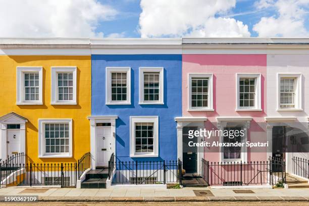 multi-colored vibrant row of terraced houses in notting hill, london, uk - daily life in london photos et images de collection