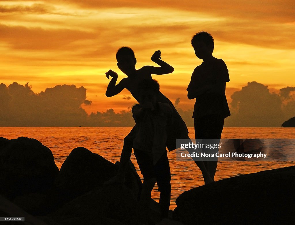 Silhouttes of kids at sunset in Sabah Borneo