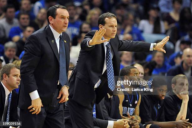 Associate Head Coach Chris Collins of the Duke Blue Devils signals instructions as Head Coach Mike Krzyzewski looks on from the sideline against the...