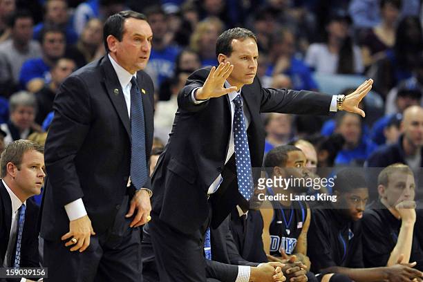Associate Head Coach Chris Collins of the Duke Blue Devils signals instructions as Head Coach Mike Krzyzewski looks on from the sideline against the...