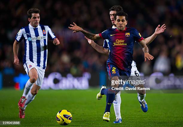 Dani Alves of FC Barcelona duels for the ball with Juan Forlin and Victor Sanchez of RCD Espanyol during the La Liga match between FC Barcelona and...