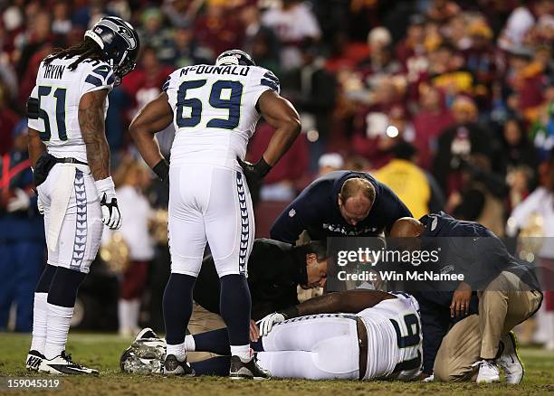 Chris Clemons of the Seattle Seahawks receives medical attention after being injured on a third quarter play against the Washington Redskins during...