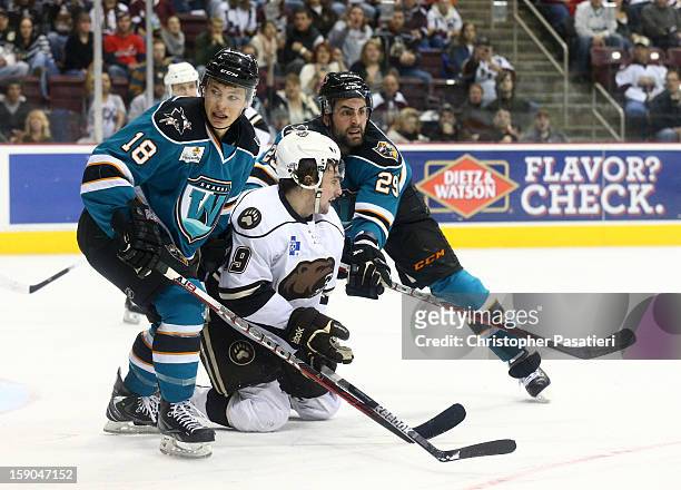 Zach Hamill of the Hershey Bears is checked by Nick Petrecki and Yanni Gourde of the Worcester Sharks during an American Hockey League game on...