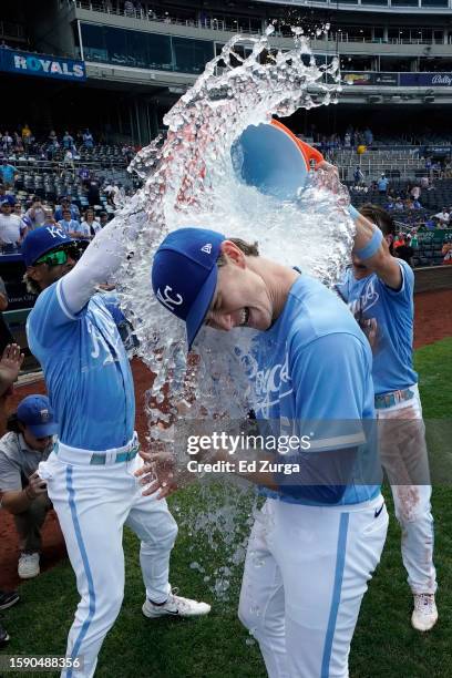 Brady Singer of the Kansas City Royals is doused with water by MJ Melendez and Bobby Witt Jr. #7 as they celebrate a 9-2 win over the New York Mets...