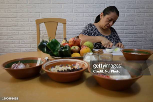 Melina Hernandez Valerio, originally from Tehuacan, Puebla, chops some ingredients for the preparation of Chiles en Nogada in Mexico City, on the eve...