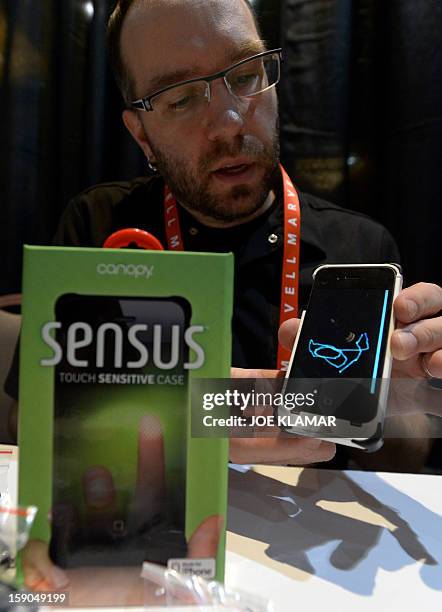 Matt Pacyga of Canopy shows Sensus touch sensitive case for iPhone during the opening event ''CES Unveiled'' during the International Consumer...