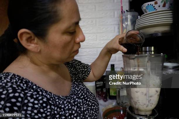 Melina Hernandez Valerio, originally from Tehuacan, Puebla, pours cheese and sherry into a blender to make Chiles en Nogada in Mexico City, on the...