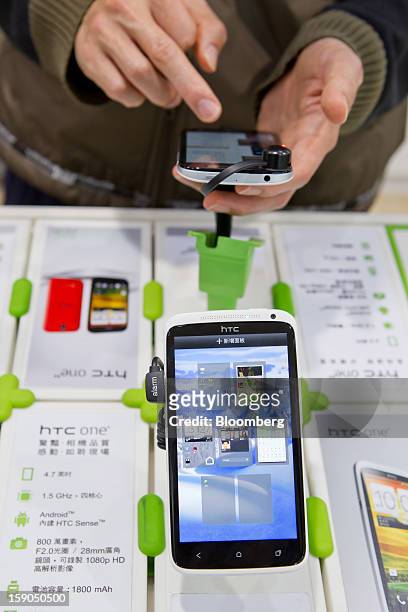 Customer tries out an HTC Corp. One X smartphone at one of the company's stores in Taipei, Taiwan, on Sunday, Jan. 6, 2013. HTC is scheduled to...