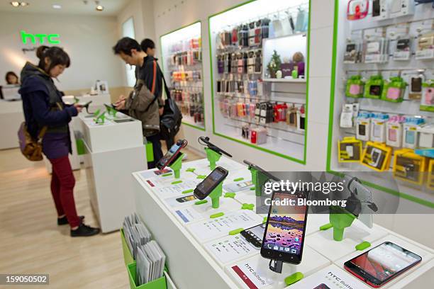 The HTC Corp. Butterfly smartphone, right, is displayed at one of the company's stores in Taipei, Taiwan, on Sunday, Jan. 6, 2013. HTC is scheduled...