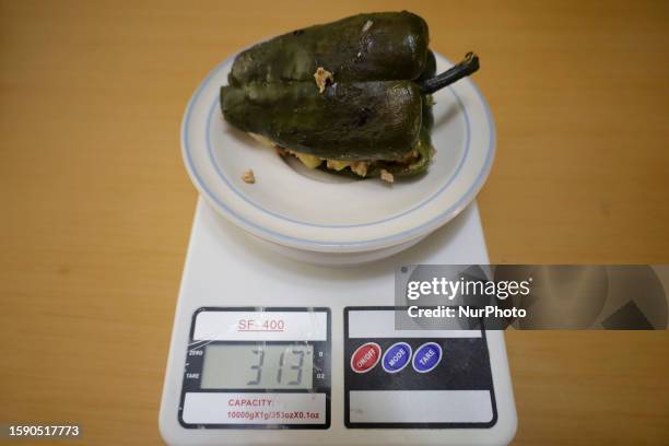 View of a poblano chili stuffed with stewed ground beef on a scale to make Chiles en Nogada in Mexico City, on the eve of the national holidays in...