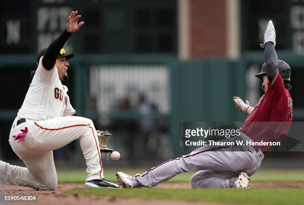 Corbin Carroll of the Arizona Diamondbacks steals second as the throw gets past Isan Diaz of the San Francisco Giants in the top of the six inning at...