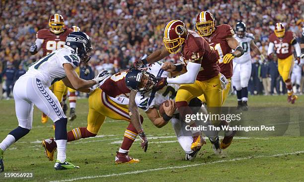 January 6: Seattle Seahawks quarterback Russell Wilson is hit by Washington Redskins free safety Madieu Williams and Washington Redskins cornerback...
