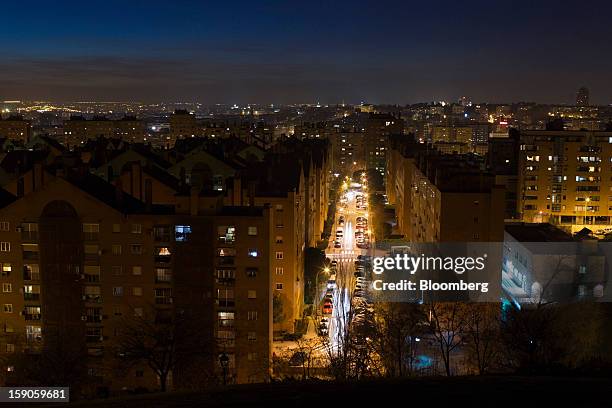 City street and residential apartments stand illuminated by electric lighting in Madrid, Spain, on Friday, Jan. 4, 2013. In December, the Spanish...