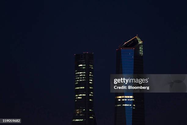 Lights illuminate offices in commercial buildings at night in Madrid, Spain, on Sunday, Jan. 6, 2013. In December, the Spanish parliament passed an...