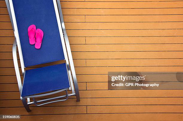 pink sandals and lounge chair - timber deck stock-fotos und bilder