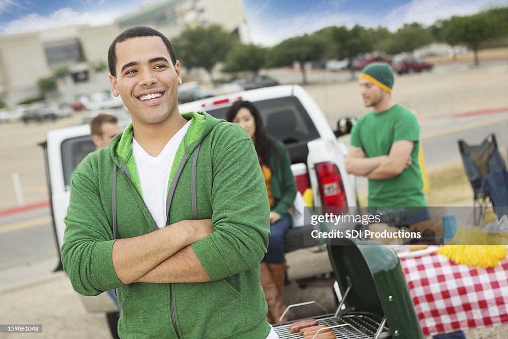 Happy college student tailgating with friends near football stadium